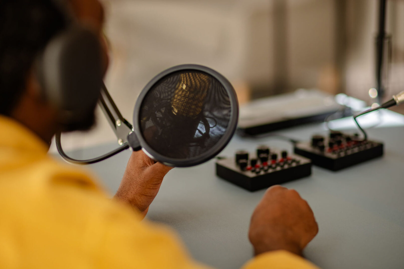 Person recording audio with microphone and equipment.