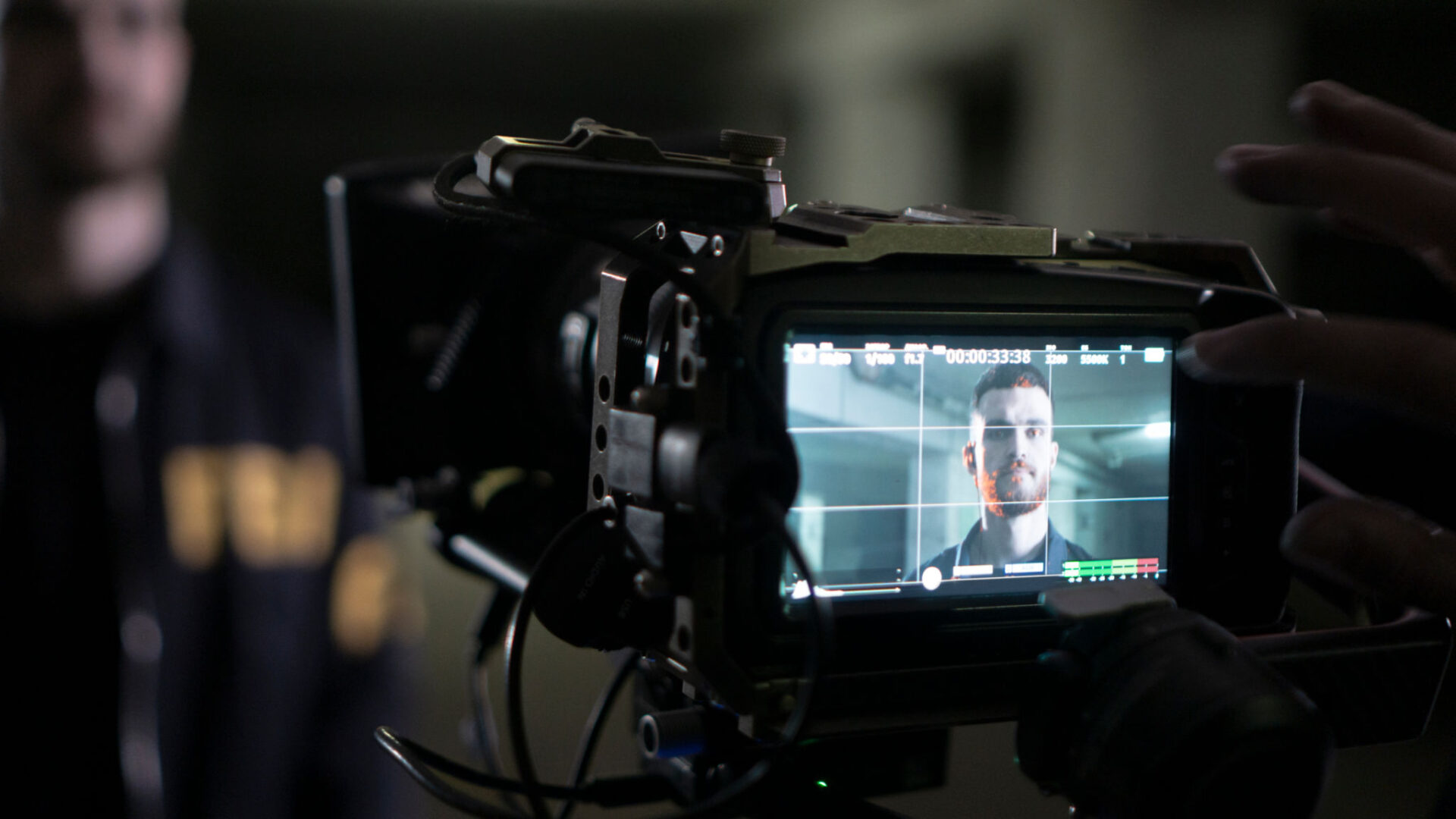 Camera filming a person in dim lighting.