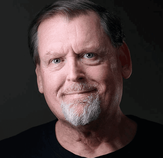 Portrait of a middle-aged man with a slight smile and gray beard.